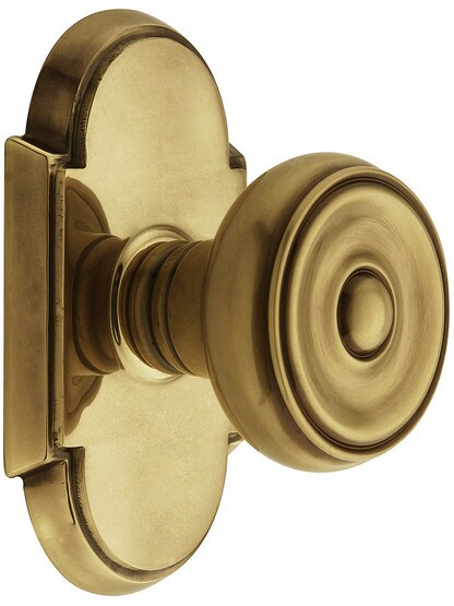 Arched Rosette Set With Waverly Knobs in Antique Brass.
